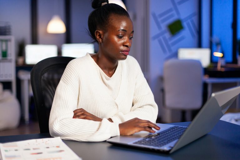 Bookkeeper woman with dark skin looking into laptop computer calculate